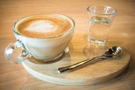 Hot coffee with syrup on a wooden plate.の写真素材