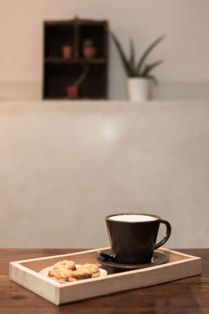 Hot coffee in a ceramic cup on a wooden plate.の写真素材