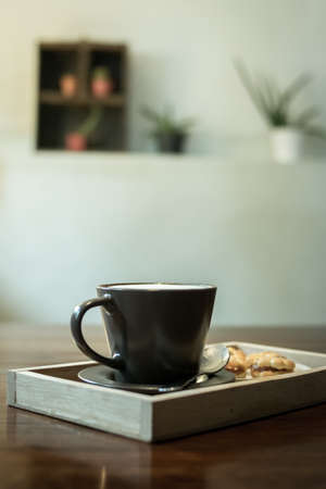 Hot coffee in a ceramic cup on a wooden plate.の写真素材