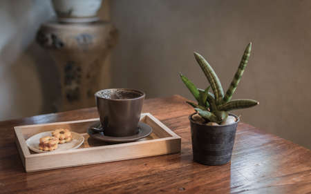 An empty coffee cup with cookies on a wooden table.の写真素材
