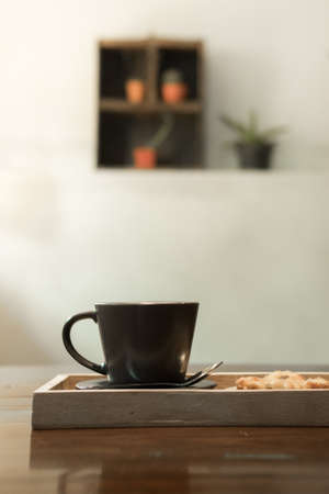 Hot coffee in a ceramic cup on a wooden plate.の写真素材