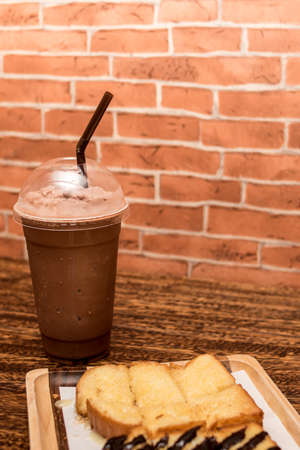 Cocoa smoothie with toast on a wooden table.の写真素材