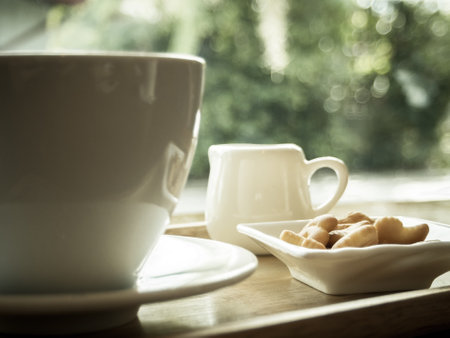Hot coffee in a ceramic cup on a wooden plate.の写真素材