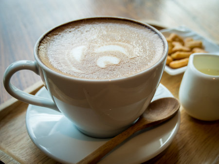 Hot coffee in a ceramic cup on a wooden plate.の写真素材