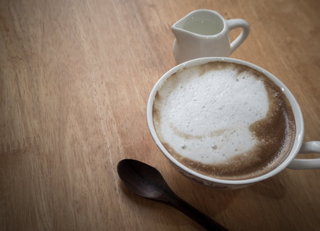 Hot coffee in a ceramic cup on a wooden tray.の写真素材