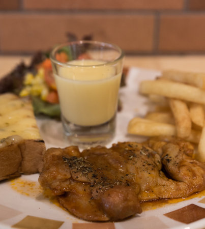 Grilled chicken with french fries served with salad.の写真素材