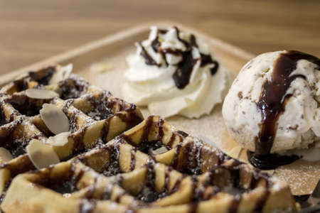 Waffle and ice cream in wooden plate.の写真素材