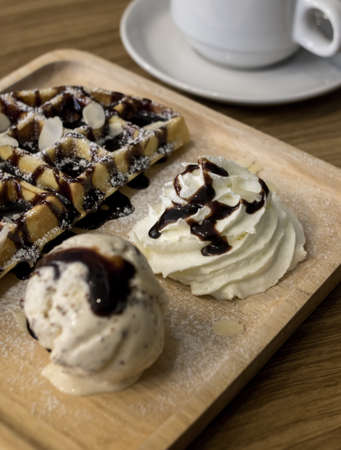 Waffle and ice cream in wooden plate.の写真素材