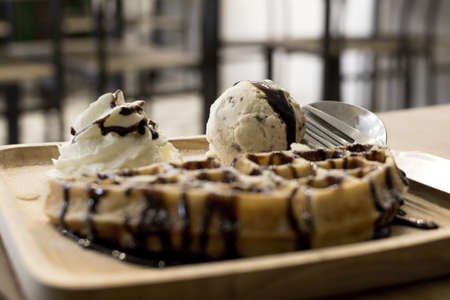 Waffle and ice cream in wooden plate.の写真素材