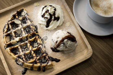 Waffle and ice cream in wooden plate.の写真素材