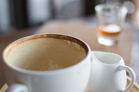 Dirty cup with food scraps on a tableの写真素材