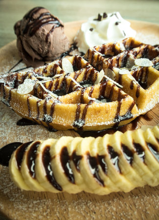 Close up of chocolate ice cream with a waffle on a wooden plateの写真素材