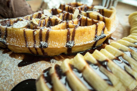 Close up of chocolate ice cream with a waffle on a wooden plateの写真素材