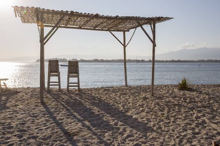 Tropical sandy beach with buildings and boats in a sea. Gili Trawangan, Indonesiaの写真素材