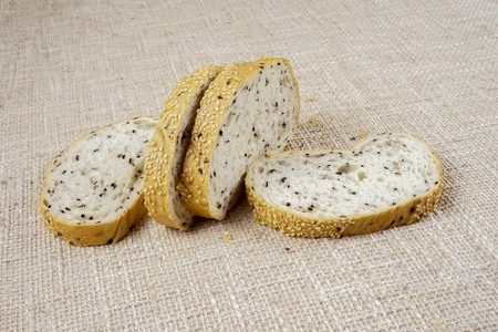 fresh sliced bread and wheat on wooden board isolated on whiteの写真素材