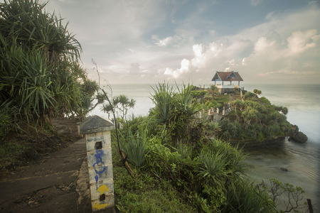 Sea waves crashing over rocks on the wild stone beach in sunset time and seafoam created by the agitation of seawater in the moment of ocean waves crashing against rocks.の写真素材