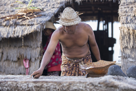 BALI, INDONESIA - May 8,2015 : Unidentified local people work as natural salt farmer at Kasumba Beach, Bali. He collecting sea water and make salt naturally.のeditorial素材