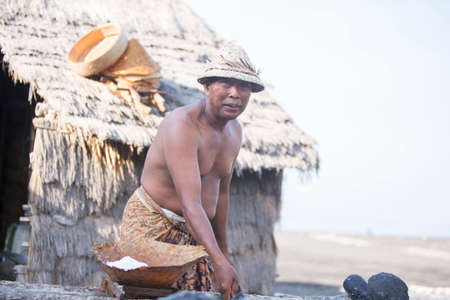 BALI, INDONESIA - May 8,2015 : Unidentified local people work as natural salt farmer at Kasumba Beach, Bali. He collecting sea water and make salt naturally.のeditorial素材