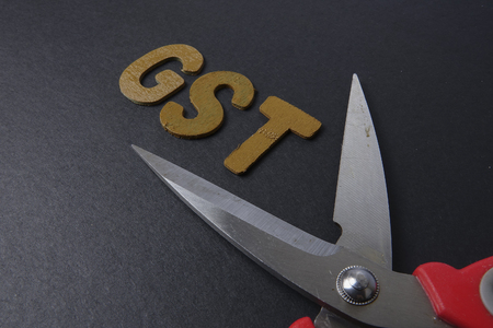 Scissors and word of GST on black backgroundの写真素材