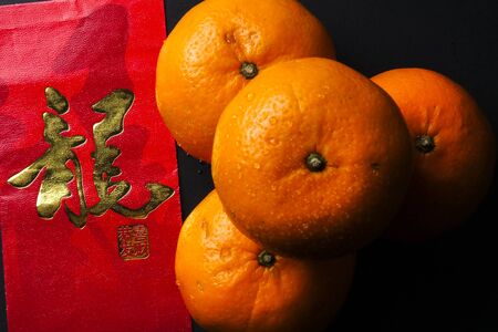 Chinese new year festival decorations,  red packets and mandarin oranges, golden Chinese letter means luckの写真素材