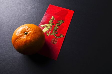 Chinese new year festival decorations,  red packets and mandarin oranges, golden Chinese letter means luckの写真素材