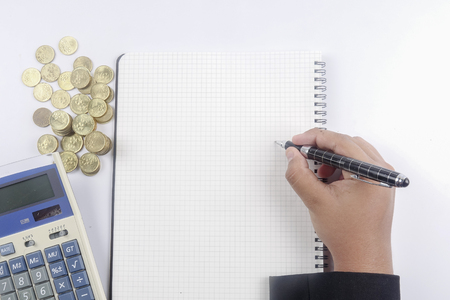 Close-up Of A Businessman writing Report with Stack Of Coinsの写真素材