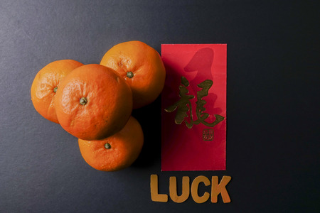 Wording of LUCK ,ang pow or red packets and mandarin oranges, golden Chinese letter means luck