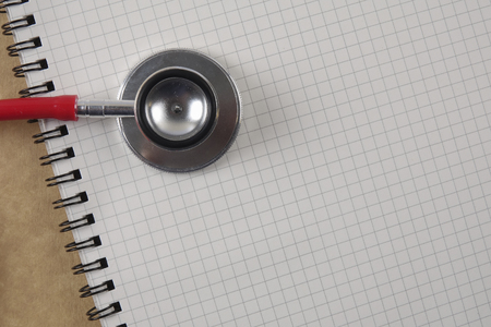 Red stethescope on wooden background. Medical and health care concept.の写真素材