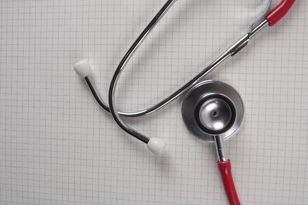 Red stethescope on wooden background. Medical and health care concept.の写真素材