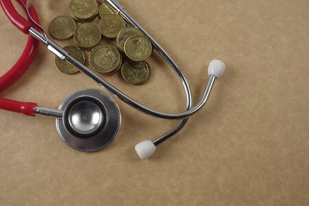 Red stethescope on wooden background. Medical and health care concept.の写真素材