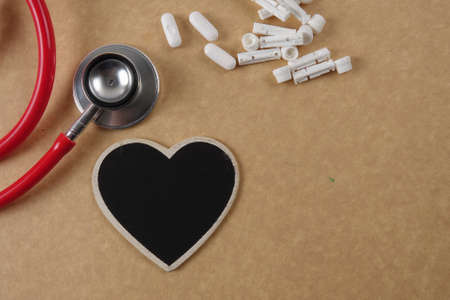 Red stethescope on wooden background. Medical and health care concept.の写真素材