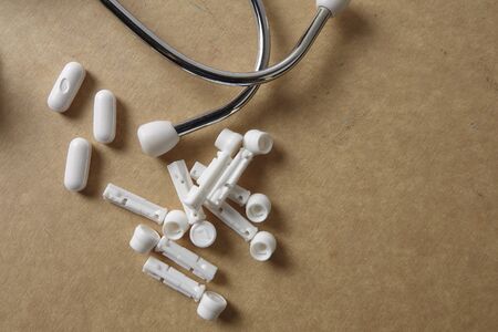 Red stethescope on wooden background. Medical and health care concept.の写真素材