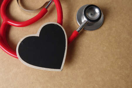 Red stethescope on wooden background. Medical and health care concept.の写真素材