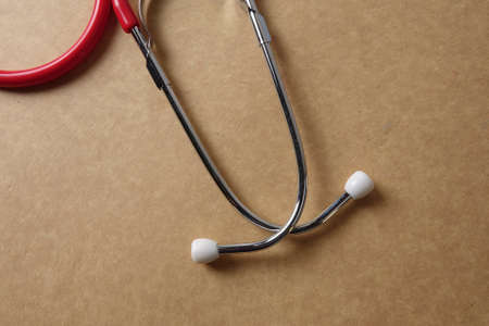 Red stethescope on wooden background. Medical and health care concept.