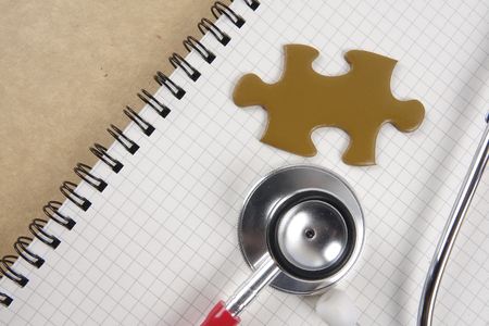 Medical concept with stethoscope,piece of puzzle and coins .の写真素材