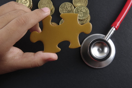 Gold puzzle stand out within white puzzles on black background.の写真素材