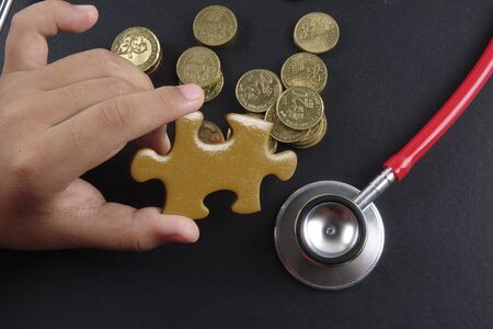 Gold puzzle stand out within white puzzles on black background.の写真素材