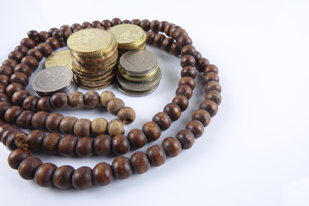 Rosary and coins on white background. Islamic business concept.の写真素材