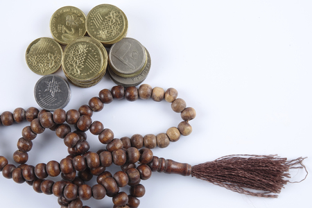 Rosary and coins on white background. Islamic business concept.の写真素材