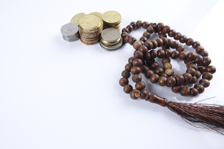 Rosary and coins on white background. Islamic business concept.の写真素材