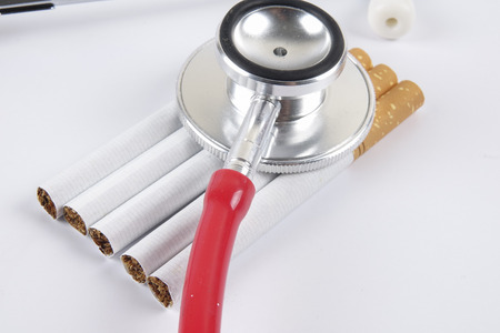 Stethoscope and cigarette isolated on white background. Medical conceptの写真素材