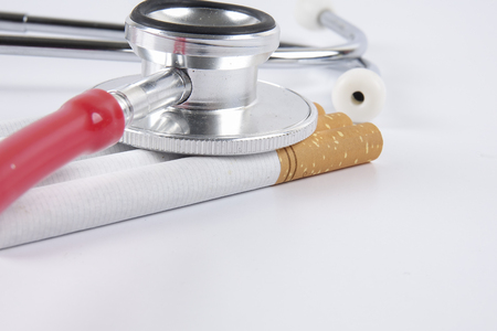 Stethoscope and cigarette isolated on white background. Medical conceptの写真素材