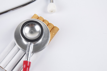 Stethoscope and cigarette isolated on white background. Medical conceptの写真素材