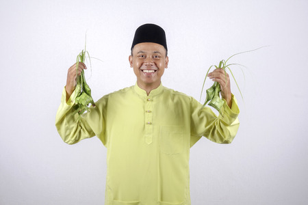 Young muslim adult holding rice dumpling during Eid Mubarak.の写真素材