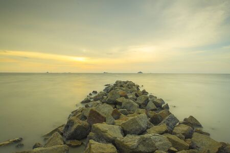 Scenery of sunset captured at Pantai Remis, Selangor, Malaysia. The motion of cloud and water is due to long exposure effect. Low lightの写真素材