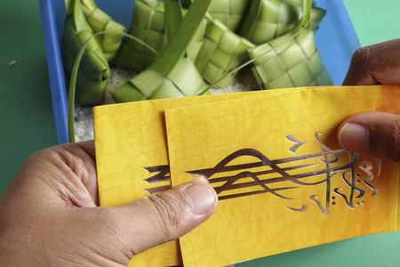 Giving and receiving money packet during Eid Fitri. Arabic character means Eid Mubarakの写真素材