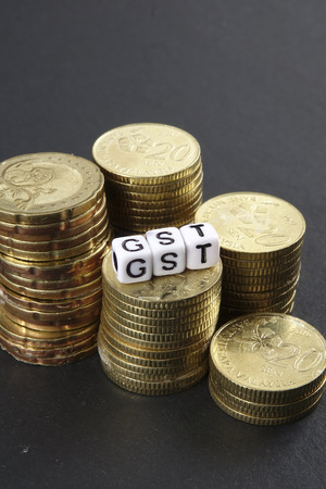 Stack of coins and GST word. Business and taxation concept.の写真素材
