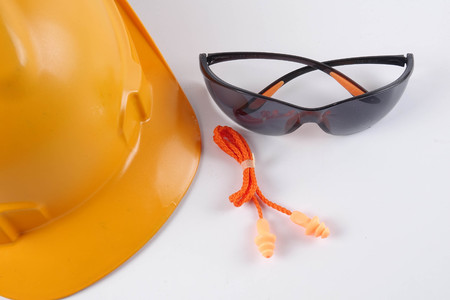 Yellow hardhat safety helmet,safety glass and ear plug isolated on white background. Industrial safety and health conceptual.の写真素材