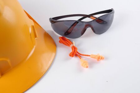 Yellow hardhat safety helmet,safety glass and ear plug isolated on white background. Industrial safety and health conceptual.の写真素材