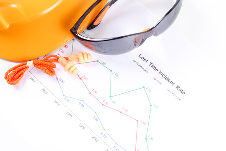 Yellow hardhat safety helmet,safety glass and ear plug over accident statistic graph as a...